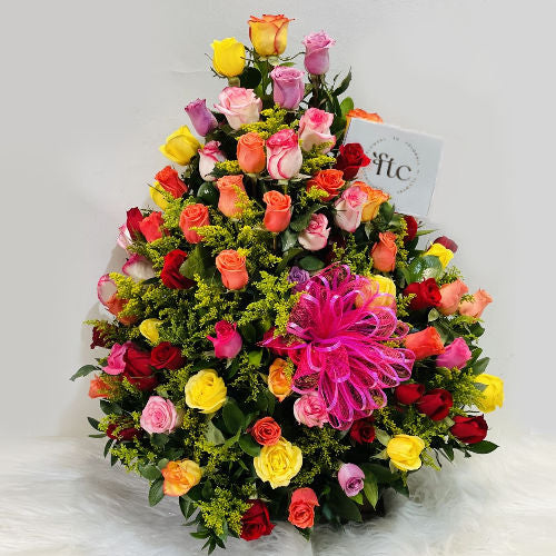 Arrangement of 120 assorted roses in rustic base with seasonal foliage and decorative bow