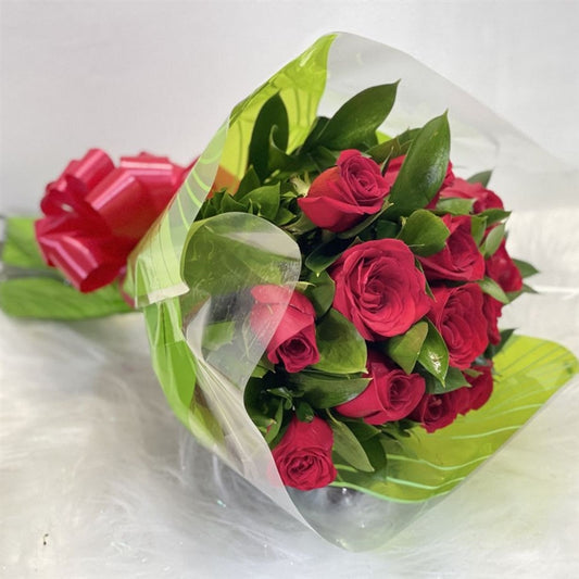 Bouquet of 12 red roses wrapped in paper with ribbon, available for delivery in all cities of Colombia