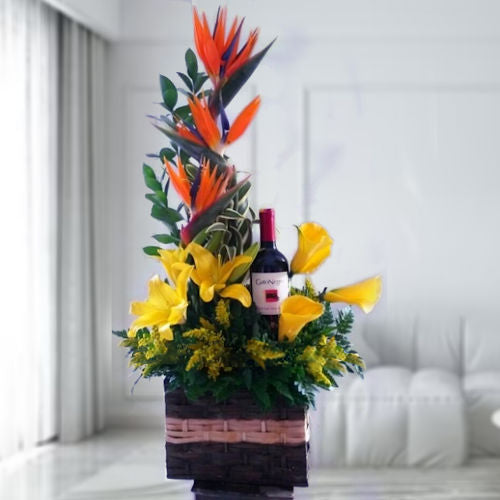 Exotic flower arrangement with Birds of Paradise, calla lilies, and lilies paired with a bottle of Gato Negro wine – available for delivery in Cali, Colombia